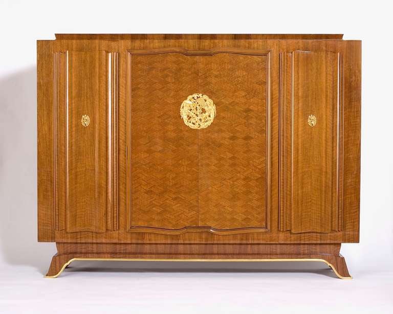 Armoire à quatre portes en noyer de Jules Leleu avec médaillon en bronze de Champreix

Pour une illustration d'un meuble identique, voir Mobilier et Décoration, no. 5. décembre 1946.

Pour une esquisse d'un cabinet identique, voir Siriex,