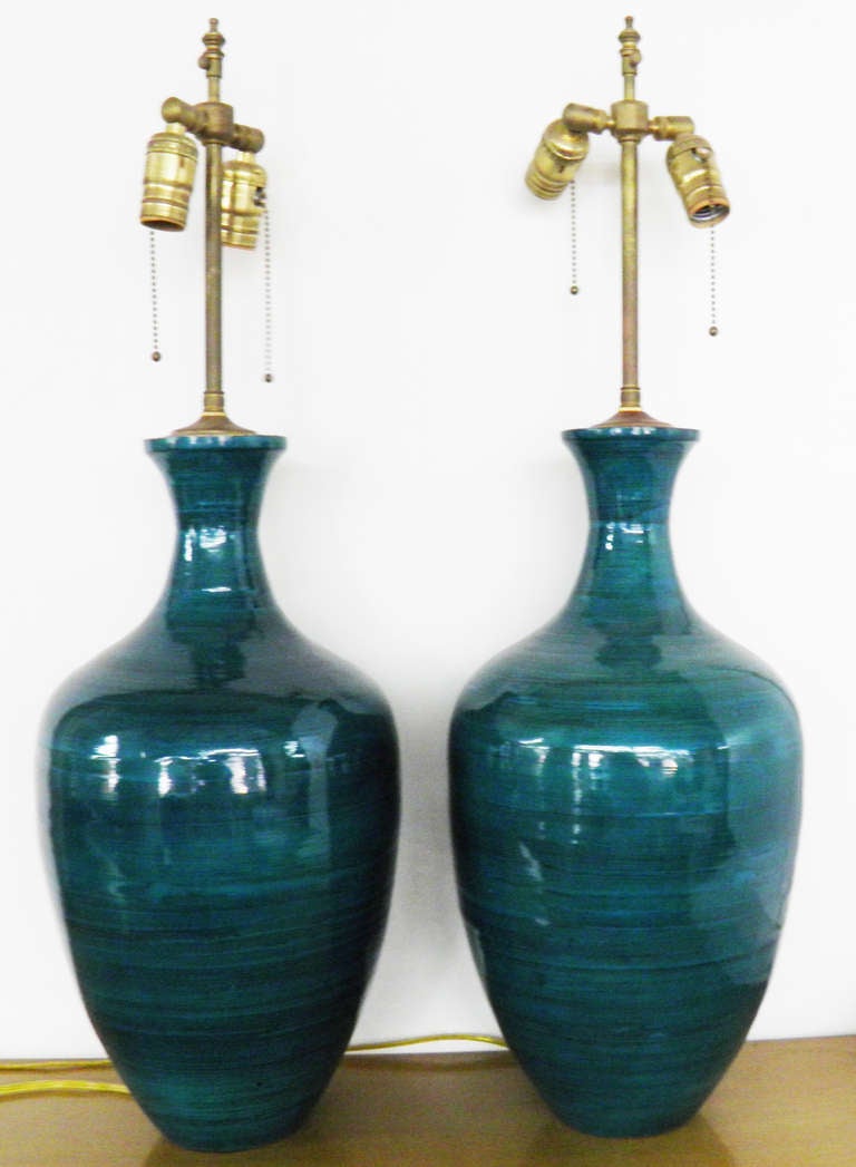 Pair of Turquoise & Deep Blue ceramic vases with lamp application.  The hardware is brass 

19 3/8