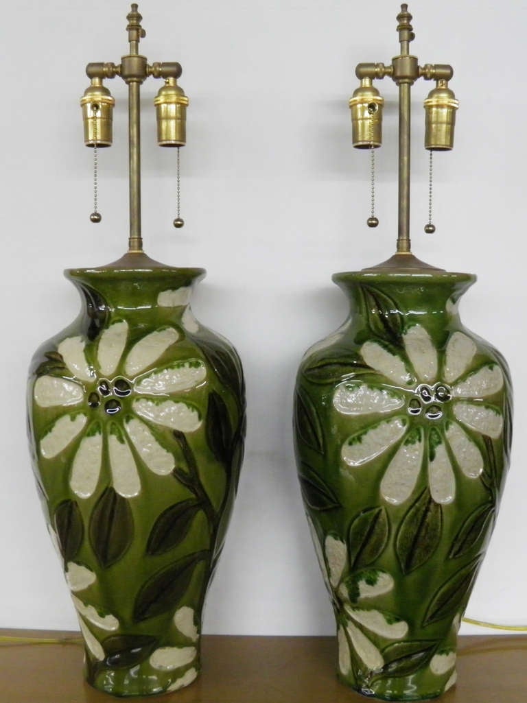 Unusual pair of textured, hand painted & glazed ceramic vases with lamp application.  The hardware is polished Brass.  The dual light sockets are individually controlled.  The finial post extends an additional 3