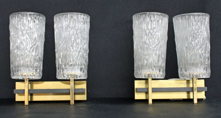 Pair of vintage textured glass twin lamp sconces with brass posts and plates.
