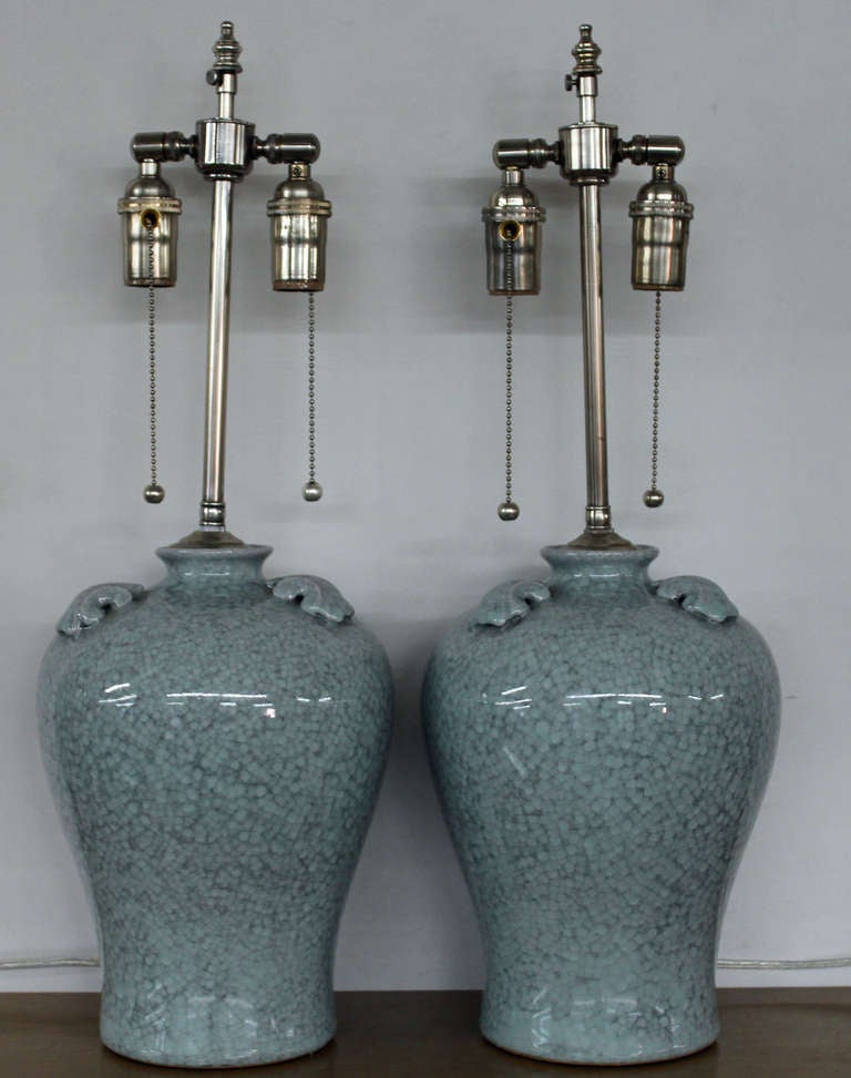 Pair of pale blue crackle finish vases with lamp application.  The brushed Nickel posts bear dual sockets with individual pull chains extends and additional 3