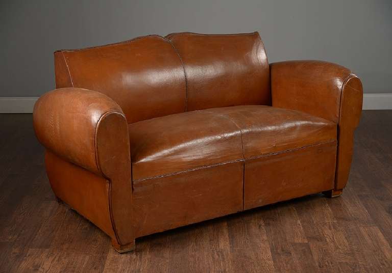 Antique French mustache back leather loveseat.