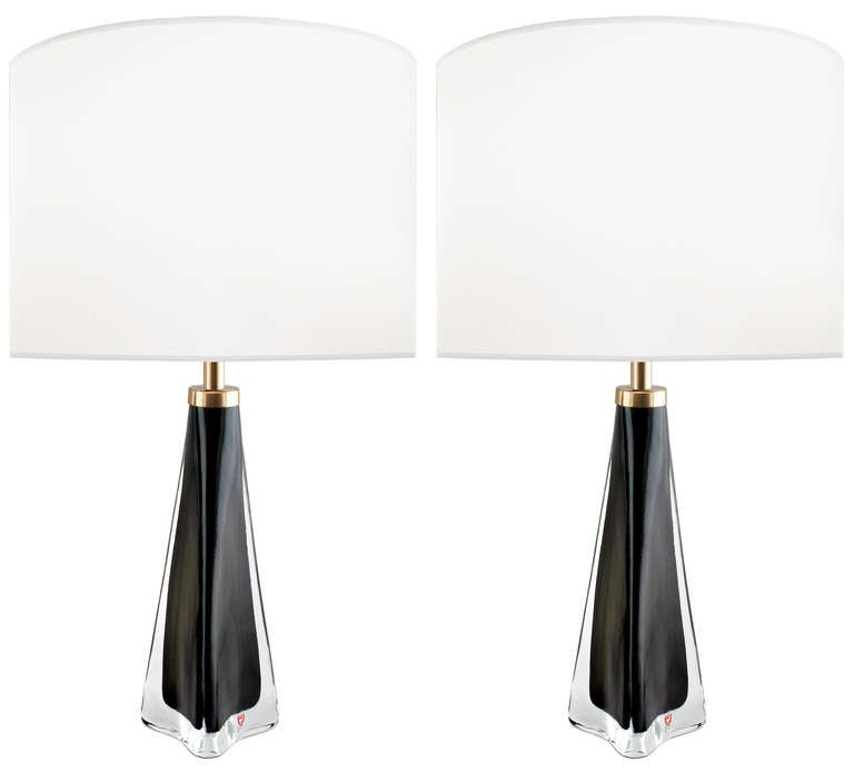 A pair of black glass lamps with a thick clear casing and brass hardware by Nils Landberg for Orrefors.

Swedish, Circa 1960s.

Lamp Shades Are Not Included.

If you are interested in Lamp Shades, please email The Craig Van Den Brulle Design Team