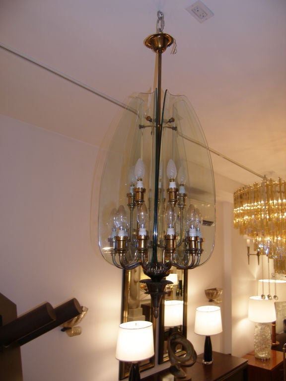 A brass chandelier with 15 lights and 5 vertical curved panels of glass featured in Domus No. 143.

Designed by Pietro Chiesa for Fontana Arte.

Italian, circa 1939

In stock.
