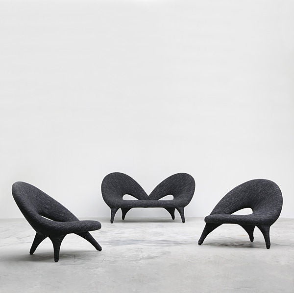 A gracefully curving formed upholstered Arabesk sofa with cut outs to back and wood feet, designed by Folke Jansson, Sweden C.1955.<br />
<br />
The two seat sofa is very rare. The sofa has been reupholstered with black, gray and white wool fabric.