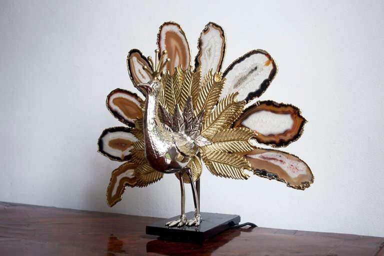 A bronze peacock lamp resting on a black stone base with 9 agate stones as feathers by Willy Daro.

Belgium, Circa 1970's