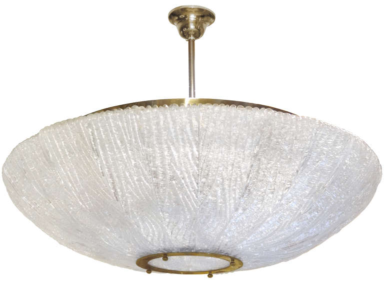 A textured glass chandelier consisting of multiple bans of glass hung around a center textured glass disk with brass hardware by Venini.

Italian, Circa 1960's