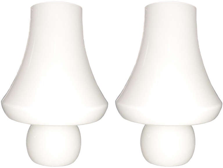 A pair of large warm white glass lamps molded from one piece of glass with two lights in each a bottom and and top light.

Italian, Circa 1970's