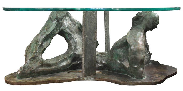 “Silence” a one-of-a-kind sculptural coffee table of a reclining male, cast solid bronze with a patinated bronze base, with a thick sculpted glass top by Philip and Kelvin Laverne, American 1970s (signed “Philip and Kelvin Laverne”). 
After the