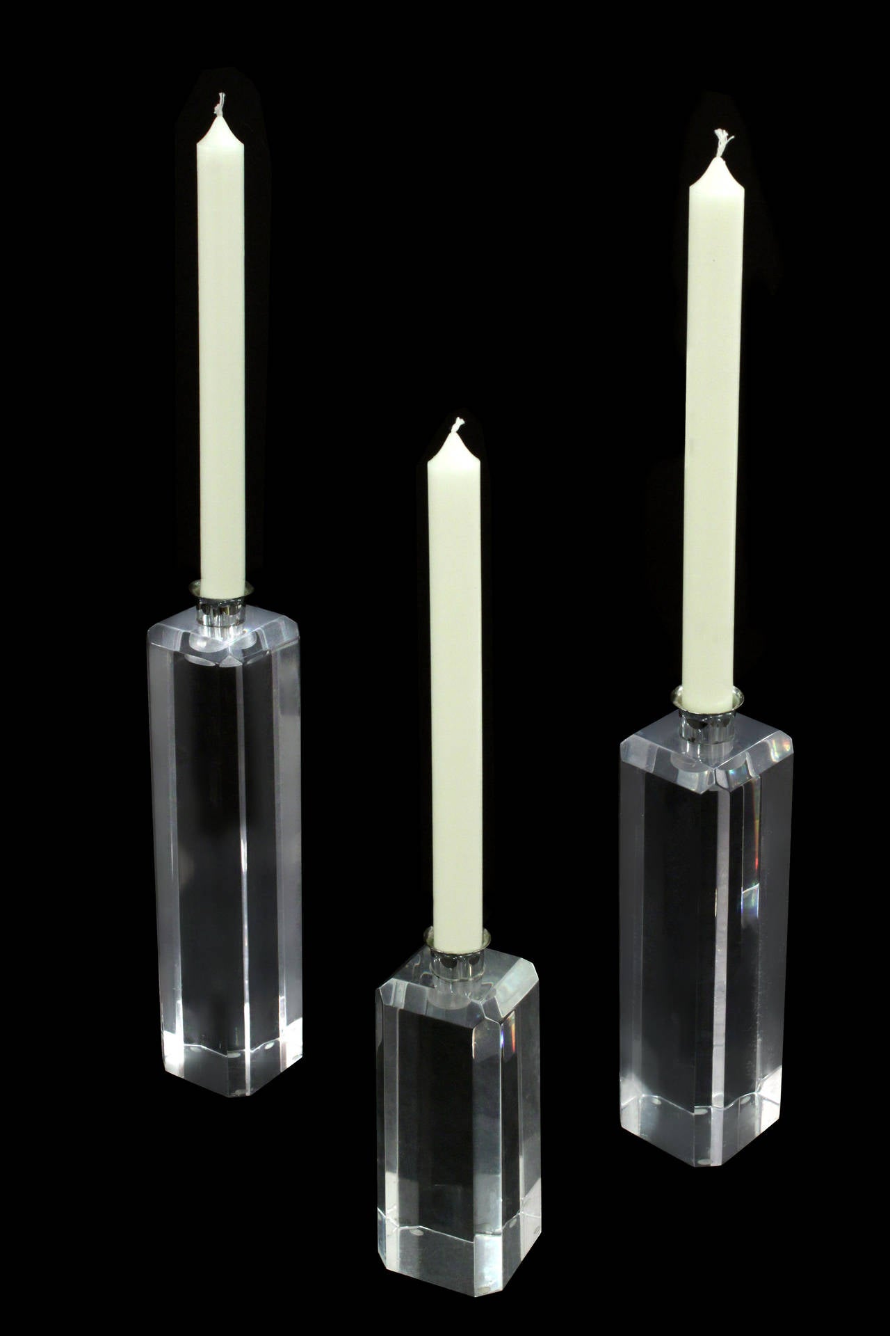 Set of three candlestick holders in Lucite and chrome, American, 1970s.

Heights of smaller candlestick holders: 
6 and 8 inches high.
