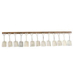 White Sandshovels Suspended from Wooden Rack with Iron Hasps