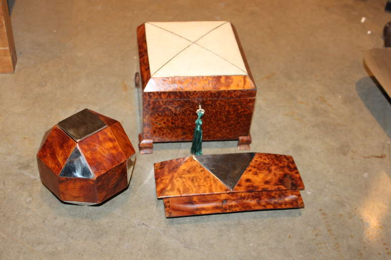 These are 3 neat boxes. The largest one retains its original key. It has a Shagreen and silver top. The second is a dodecahedron shape with random panels of nickel silver applied to it. The last is a very speak desk box which has a nickel top. These