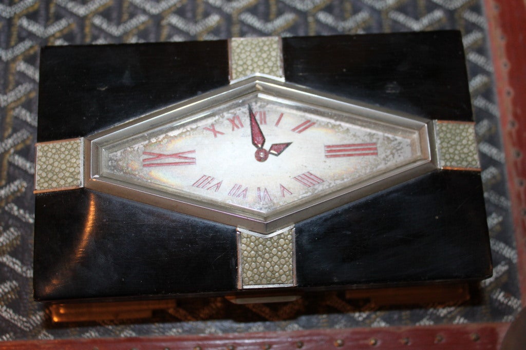 This is a super rare box by the famous retailer Alfred Dunhill. The box is ebony and nickel silver with an outrageous clock set in the middle. The stretched deco numbers are all hand painted .The interior of the box is lined in burl maple.  The