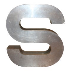 A large Aluminum over Wood Trade Sign in the form of an S