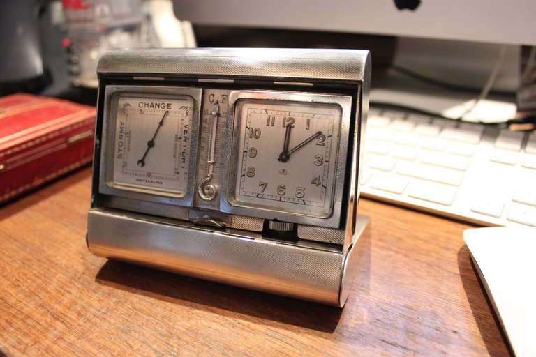 This amazing Folding Asprey clock weather station is engine turned. It has a Clock , barometer and Thermometer and the movement is an 8 day clock. Its is made of Sterling silver and Gold.