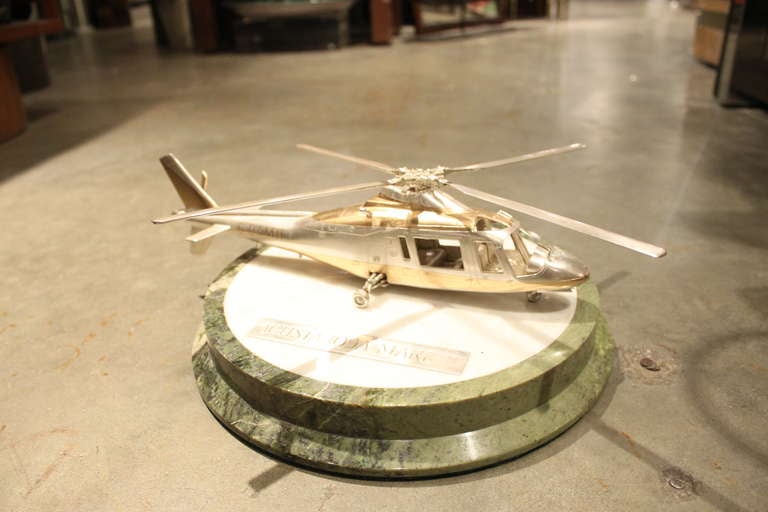 This awesome scale model of a helicopter Augusta 109A Mark II was completely made in silver and parcel gilt sterling and retailed by the famous London silver and goldsmiths Garrard. While the tail prop is fixed, the propellers do rotate. 