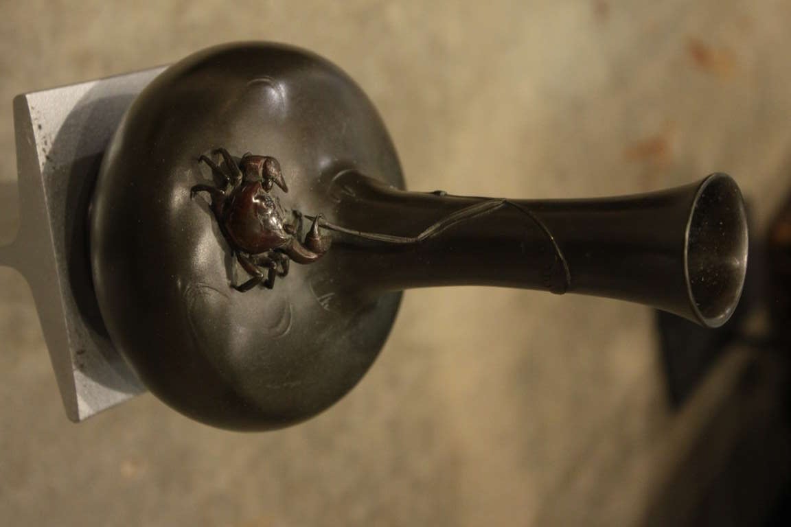 This  is a beautiful Meiji period vase with a rich greenish black patina. The crab has a rich red brown patina and details indicative of the fine craftsmanship of the Meiji period . The crab is clinging to a very fine reed that comes up as if it is