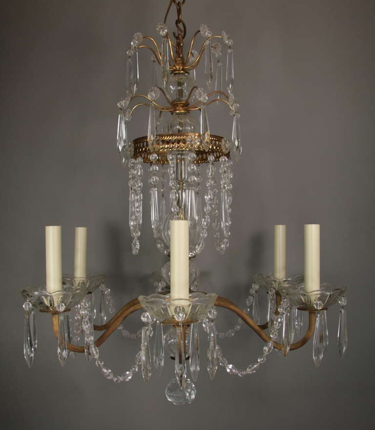 #1-2873 A six-arm brass crystal beaded chandelier dressed with rosettes, prisms and crystal beads.