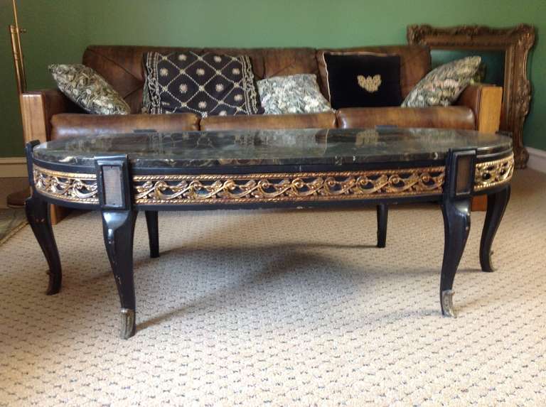 1-601  a circa 1940s black Faux marble and resin top and wood coffee table. Gilded details and brass
