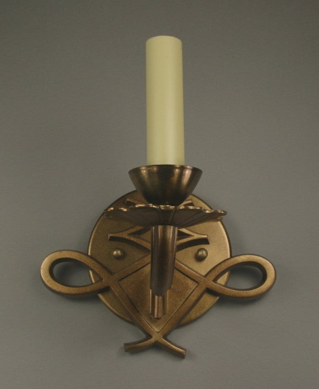 A pair of French 1940s darkened brass single-arm sconce.