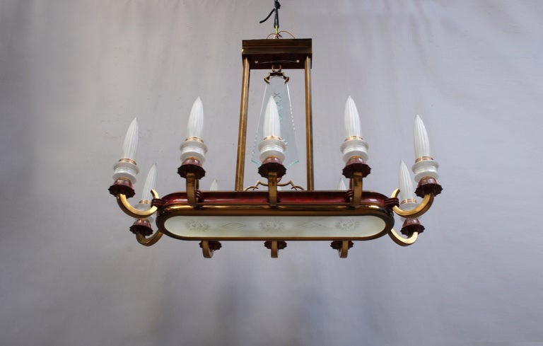 A fine large French 1950s brass and red enameled metal framed chandelier with frosted, fluted and etched glass shades.