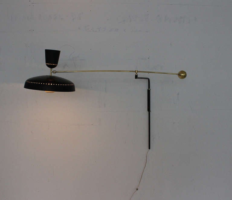 French, 1950s black painted and brass counter balance wall light by Pierre Guariche. Adjustable with the counterweight and at the shade as well.
Dimensions are W 64" maximum, diameter of the shade is 17 1/2" and height is 3' minimum.