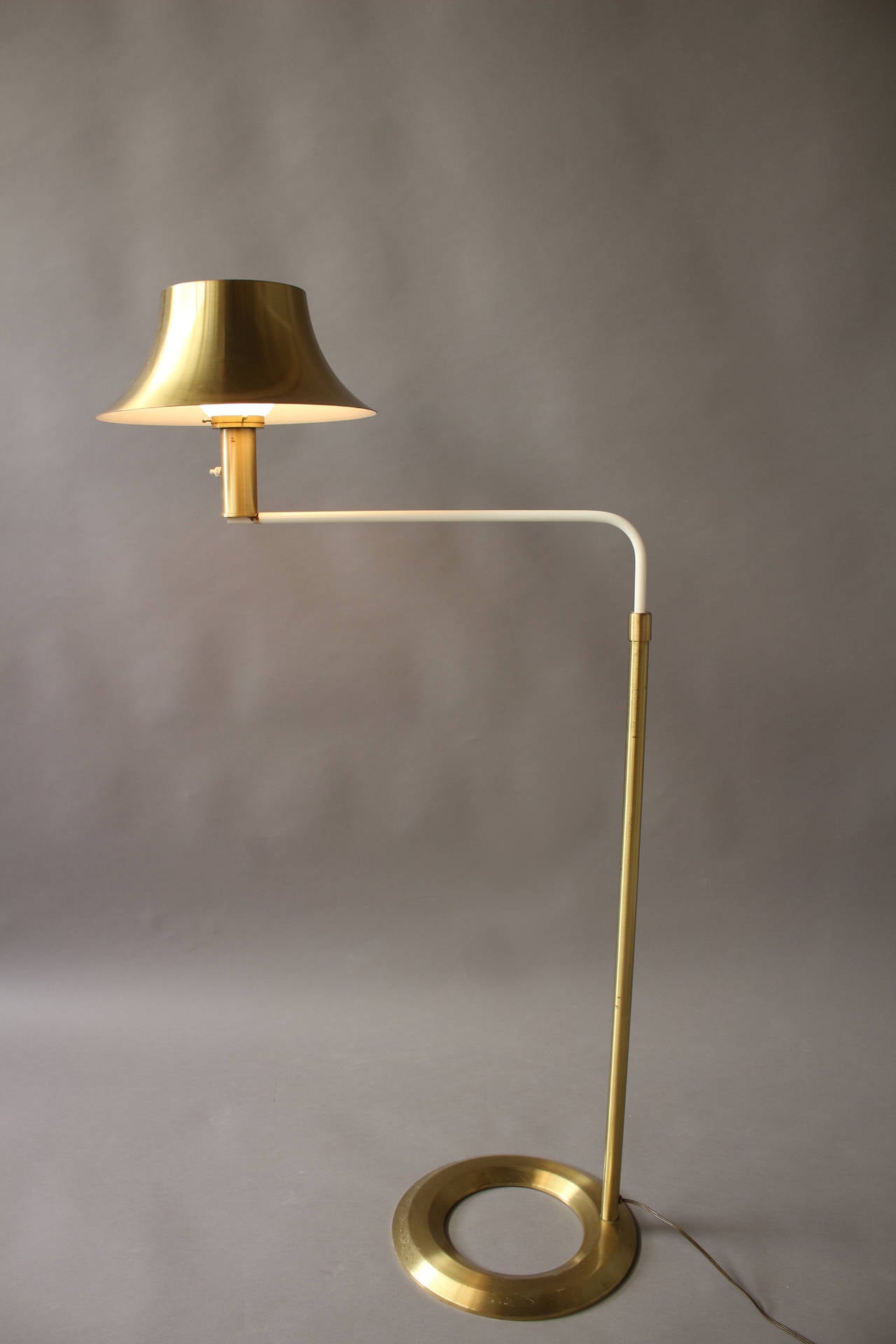 With a bronze leg and a pivoting ivory lacquered arm that support a brass and glass shade.
Perfect next to a sofa or a writing table (the hole in the base was designed to put a table leg inside)