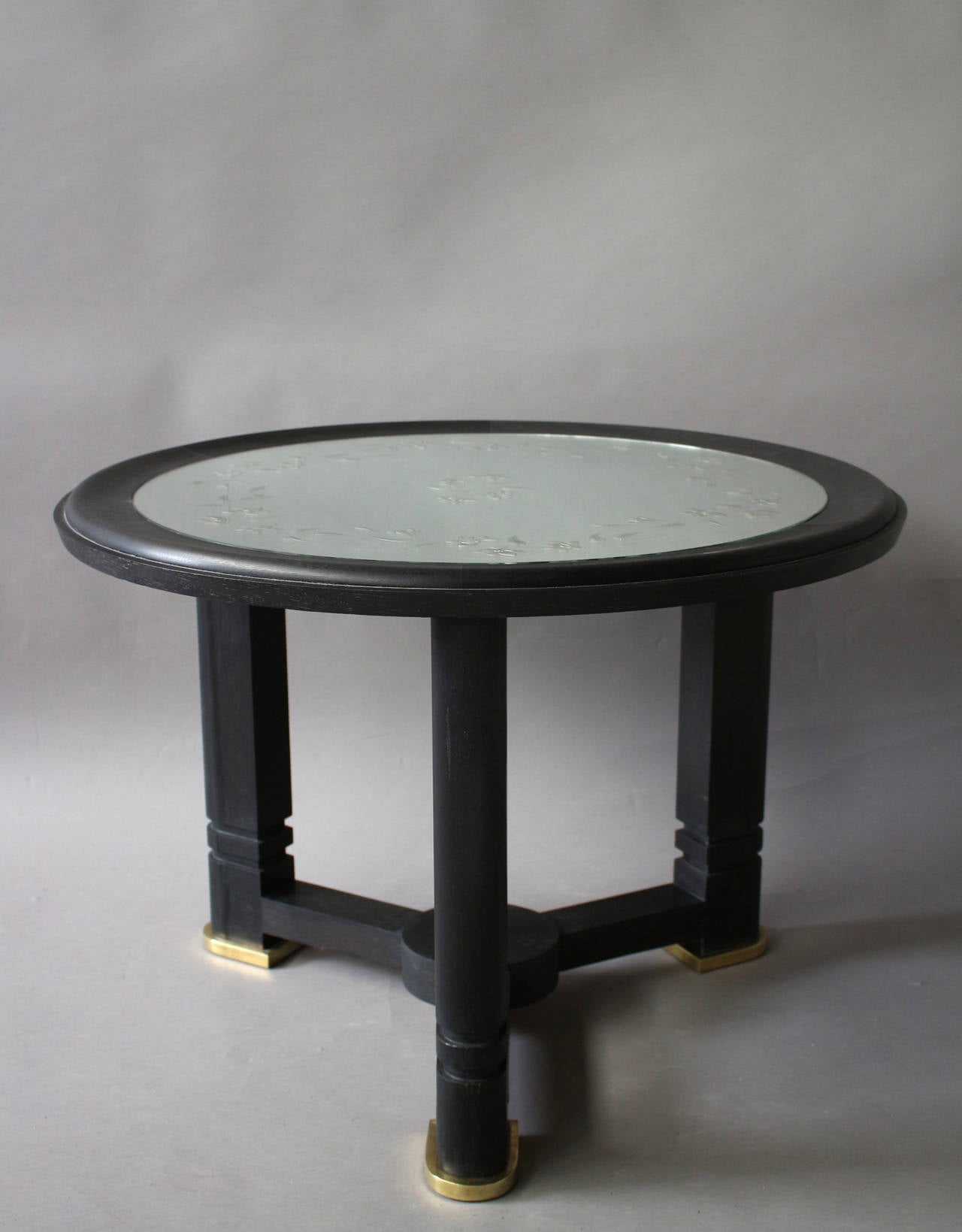 A French Art Deco blackened wood gueridon with an etched mirror top and brass details.
   