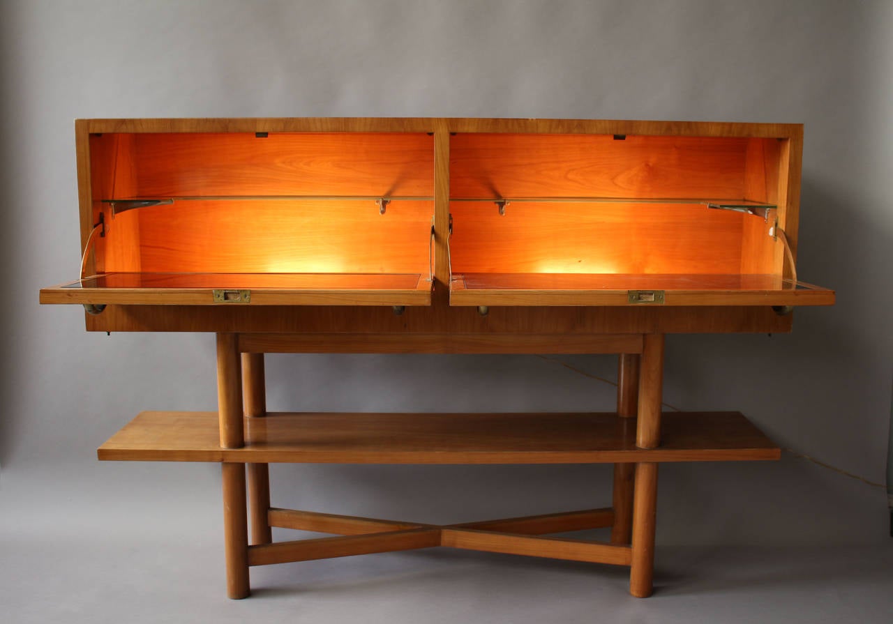 Fine French 1950s cherrywood bar with brass details by Suzanne Guiguichon.
The two pull down doors open to reveal a glass and wood interiors.
Stamped.
