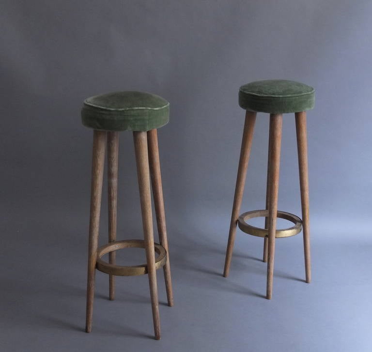 A Pair of French Art Deco cerused oak bar stools with brass details.
Dimension between legs is 15 3/8