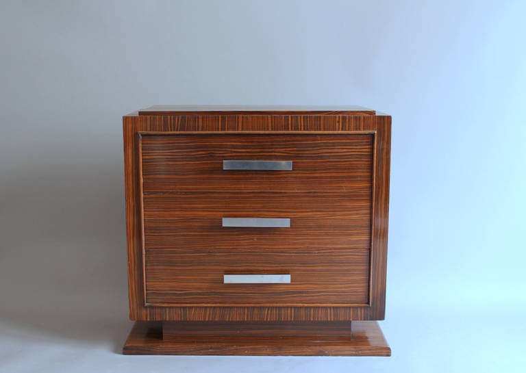 Small French Art Deco rosewood three-drawer commode with blackened wood and chrome pulls. Might be used as a nightstand.
Overall width (at bottom base) is 33 1/2