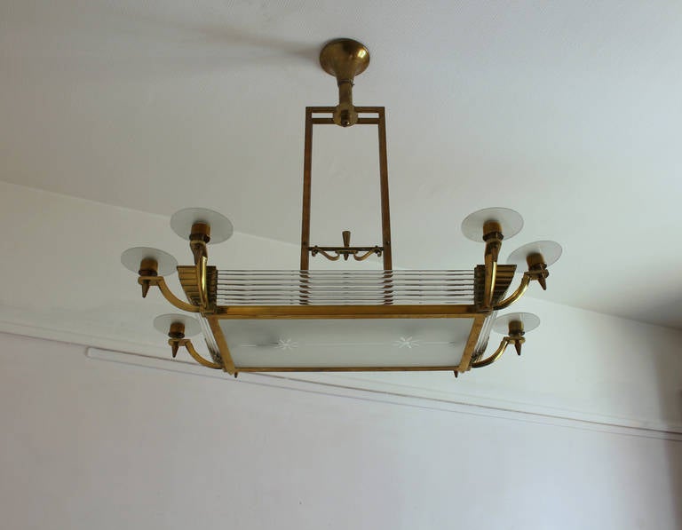 French Art Deco brass framed chandelier with glass rods and frosted glass shades by Maison Petitot.