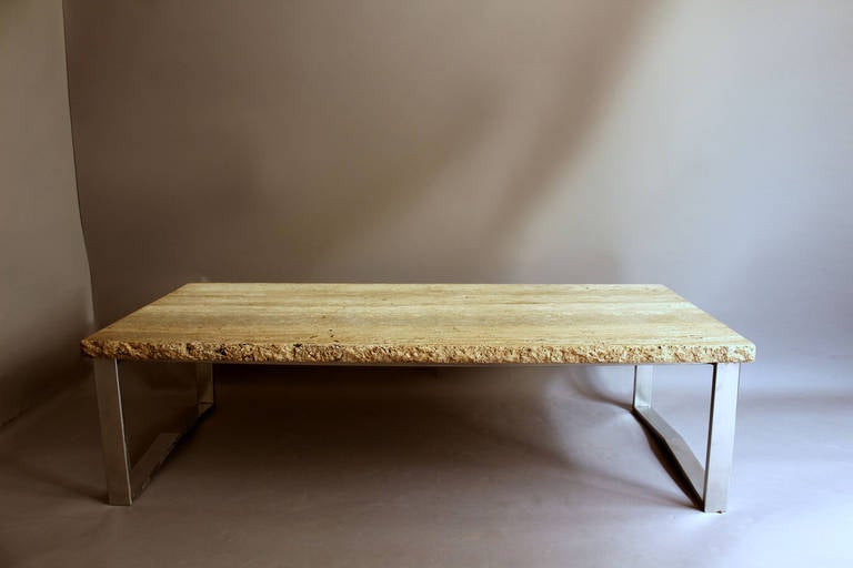 A large fine French 1970s stainless steal base coffee table with a travertine top.
