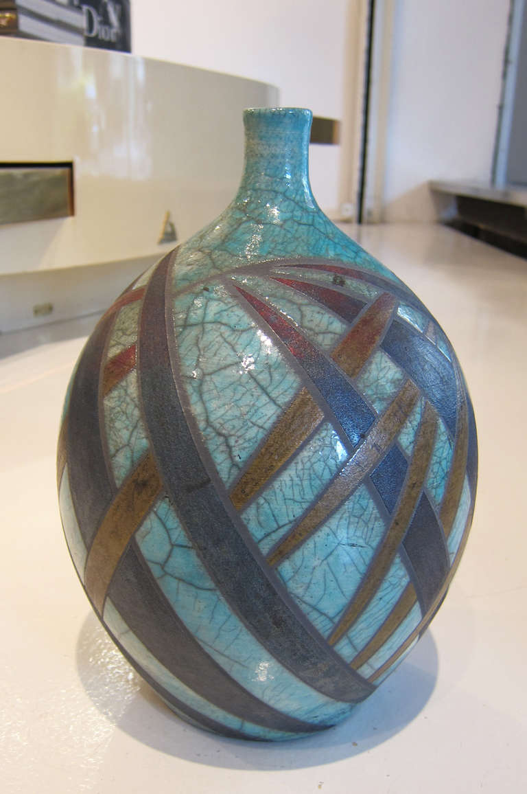 “Azure Rainbow Grasses” Raku Bottle
A Pennsylvania based potter, Deborah Slahta specializes in Raku and stoneware pottery. Slahta uses the vessel form as a three-dimensional canvas, playing with intersecting lines and geometric shapes to create