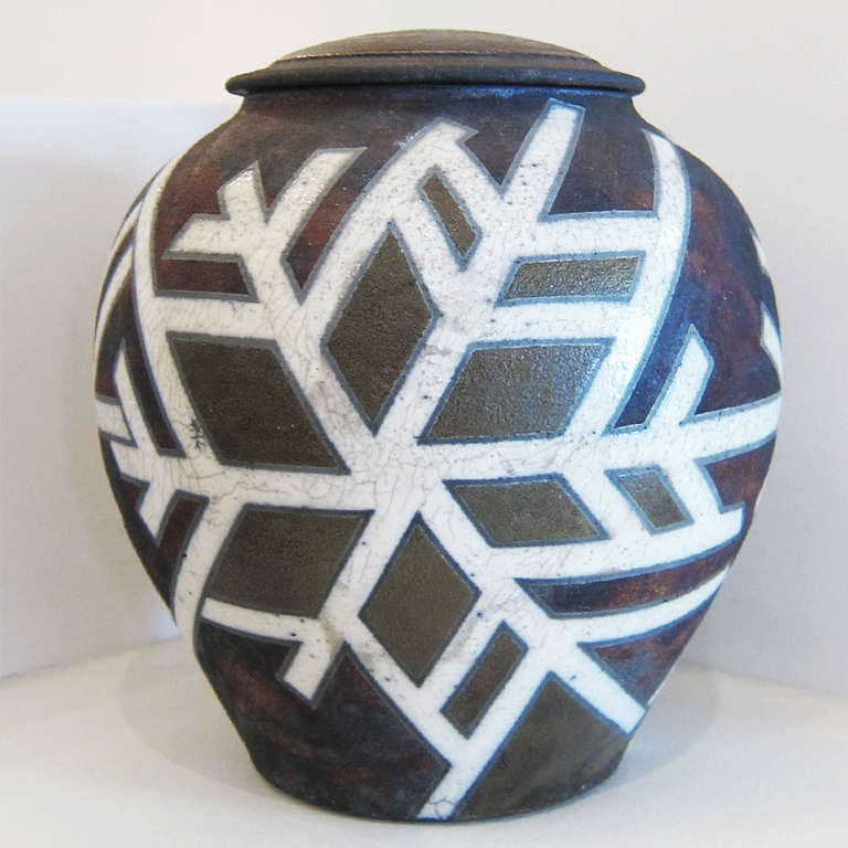 “Cinnabar Snowflake” Covered Raku Jar
A Pennsylvania based potter, Deborah Slahta specializes in Raku and stoneware pottery. Slahta uses the vessel form as a three-dimensional canvas, playing with intersecting lines and geometric shapes to create