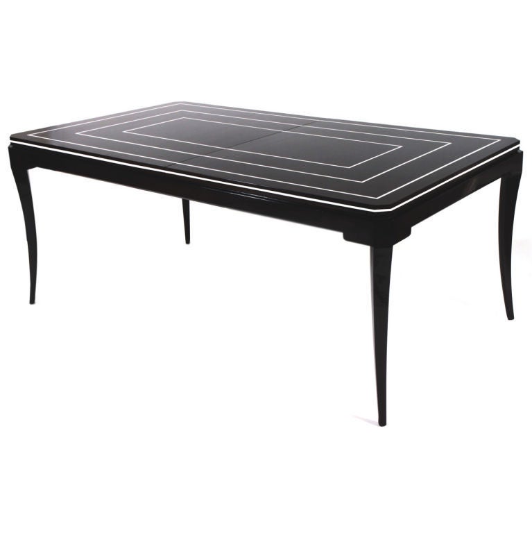 Gorgeous sabre leg mahogany dining table by Tommi Parzinger,<br />
Lacquered mahogany with ivory lacquer detail across top. Ivory lacquer piping <br />
detail at edge. Luxurious 12-14 person table with 3 removable 10