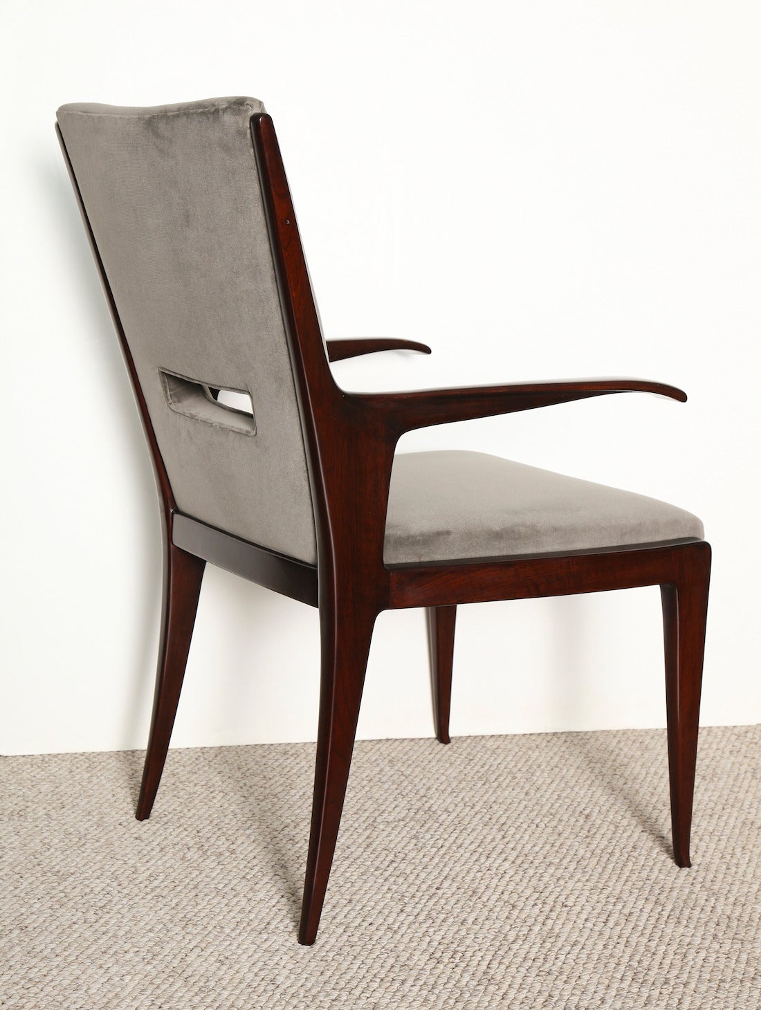 Unusual chair design with sculpted arms and cut-out on back.   Dark stained wood and light gray velvet upholstery.  *Literature; Guglielmo Ulrich, Luca Sacchetti,  Pg.188, for a similar model.