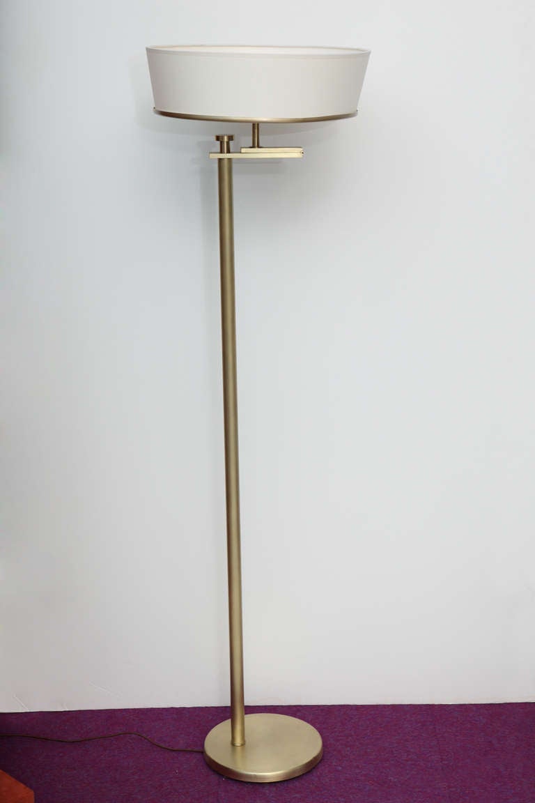 Iconic floor lamp with a great mechanism that allows the light to shine downward or flip upward.  Original satin brass finish, great hinge detail and new paper shade.