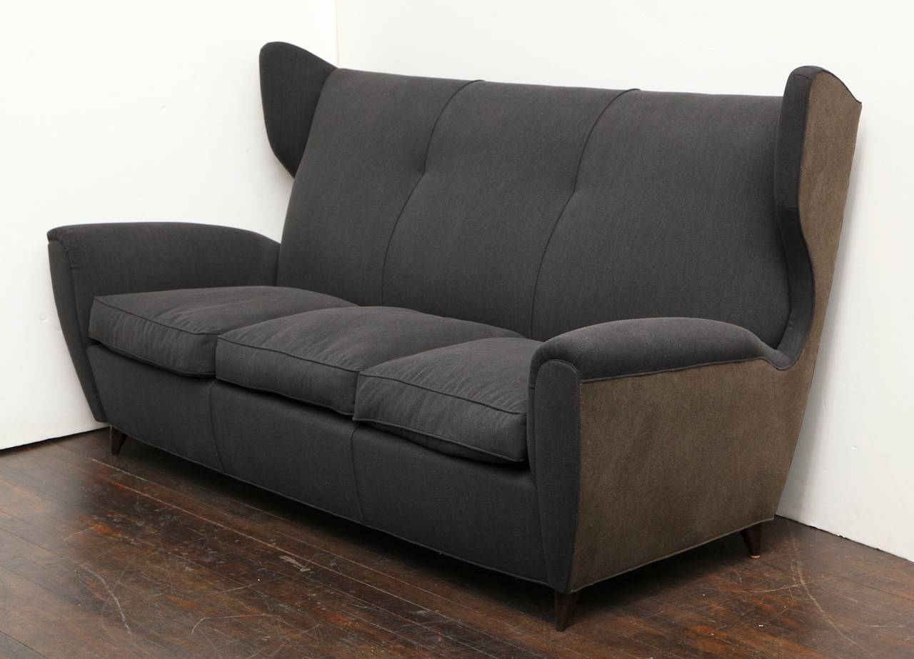 Elegant sofa with winged back details and wooden cone feet. 2-toned upholstery in charcoal gray and chocolate brown.