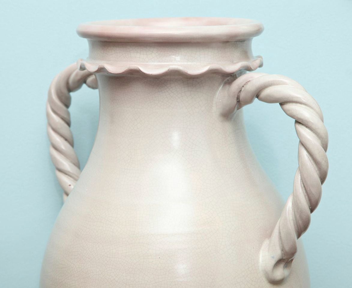 Wheel-thrown, terra cotta vessels with applied, lip and braided handles. Pale crackle glaze throughout. Signed on underside. Second matching pair available.