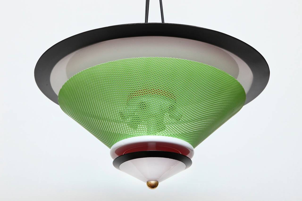 Studio-made ceiling light with enameled and perforated metal elements. Six sockets concealed behind the green, perforated reflector and three sockets above the top metal piece. A fantastic use of color and geometry.