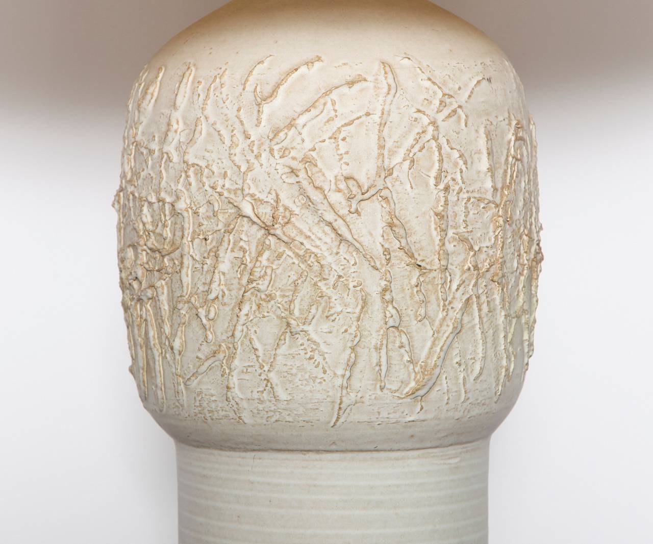 Ceramic table lamp by Lee Rosen for Design Technics.  Cylindrical earthenware form with abstract relief on bulbous upper section. Woven burlap shade in an off-white tone. Two standard sized Edison sockets. Signed with makers logo.