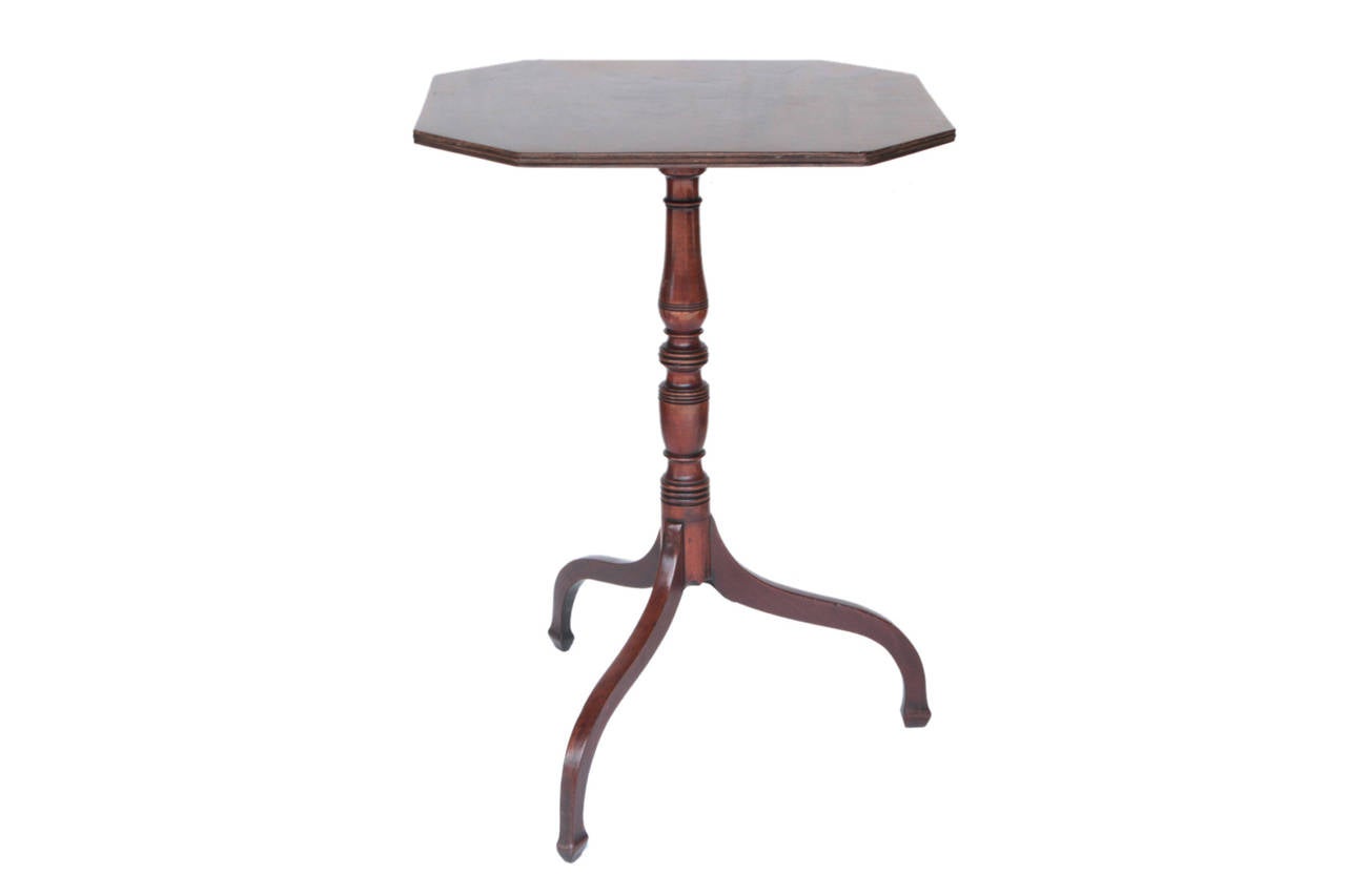 Mahogany octagonal tilt-top table with tripod base.