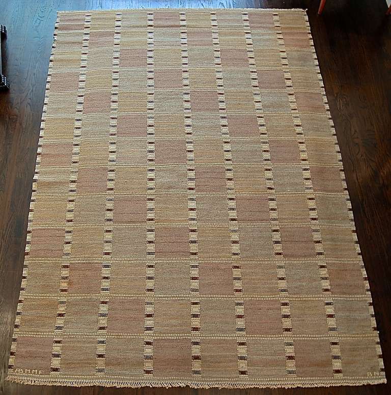 Beautiful flatweave carpet in wool by Barvro Nilsson for MMF Sweden, ca. 1960. Background in muted tones of treys with geometric patterns.Signed, AB MMF.

9' 10
