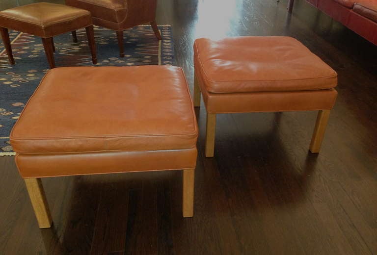 A beautiful pair of square ottomans in cognac leather on oak legs by Danish designer Børge Mogensen for Fredericia Stolefabrik. Leather is in excellent condition.