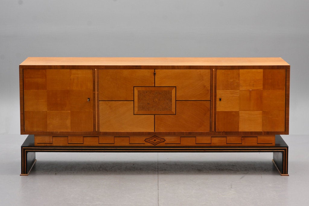 Stunning Swedish art deco credenza in birch and mixed woods, ca. 1930's
Center section with pull out drawers and shelves on either sdie.
 L 77.5