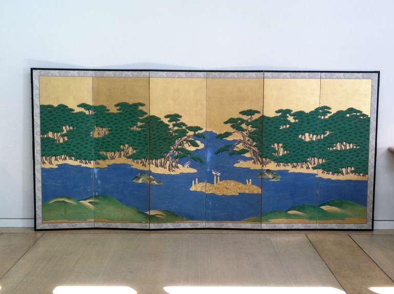 A magnificent pair of six panel screens with design of pine forest islands (possibly inspired by views from Matsushima) with fishing traps and birds. Silver foil clouds with heavy pigments on paper. A formidable expression from the Kano School circa