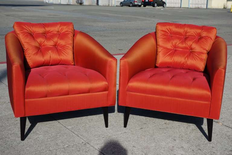 A gorgeous pair of red or orange silk or satin chairs. Beautiful tufting adds the perfect detail to these comfortable chairs.