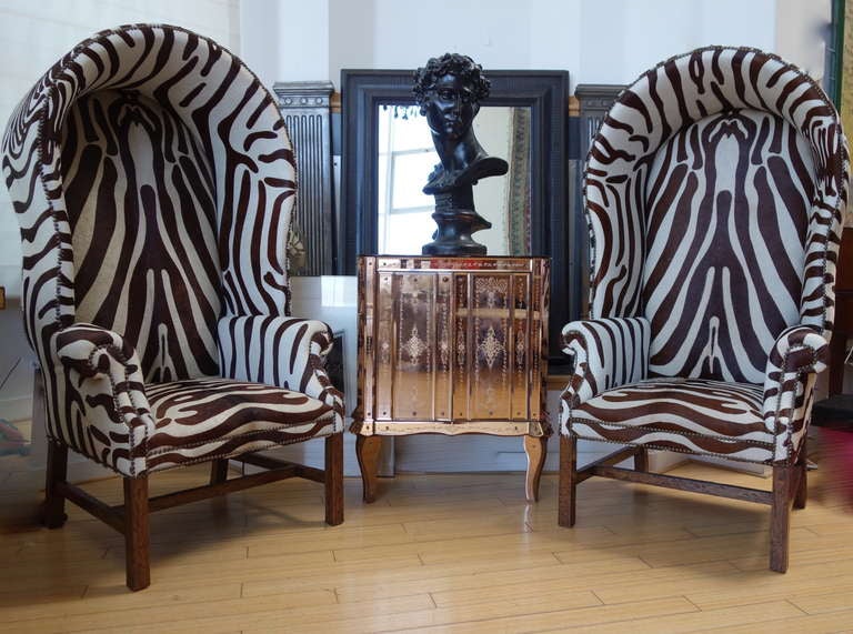 A brilliant pair of stenciled hide covered butler's chairs. Extremely well made and supremely comfortable.