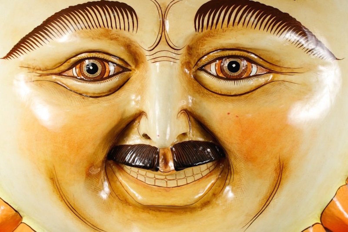 A wonderfully scaled Sergio Bustamante wall sculpture. Sergio Bustamante (Mexican, b. 1942). Polychromed papier-mache wall sculpture depicting a large male sun with bushy eyebrows, mustache and smiling, rotund face, within 25 reddish orange shaped